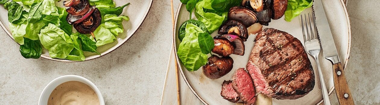 Overhead shot of sirloin medallions with a side of mushroom skewers.